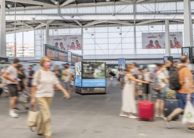 Estación AVE con pasajeros y publicidad de Inforein y Renfe.