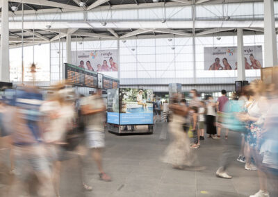 Estación AVE con pasajeros y publicidad de Inforein y Eurobasket