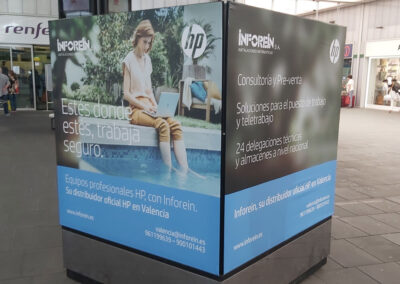 Totem Publicitario de Inforein en la estación de AVE de Valencia con pasajeros en movimiento.